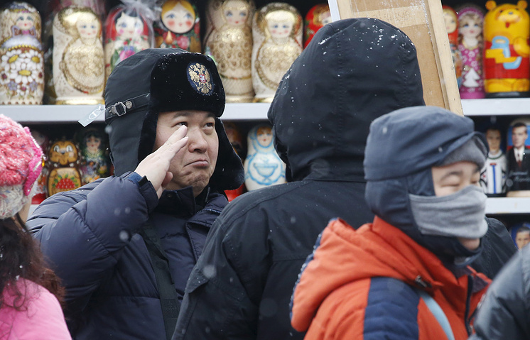 Турист из Китая в сувенирном магазине на Манежной площади